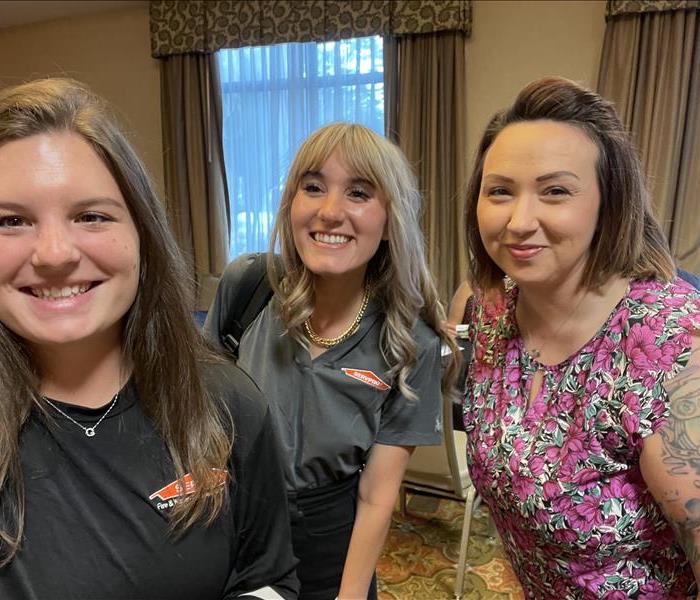 a picture of two female marketing reps and and a flagler home builder female associate. smiling at camera for a selfie.