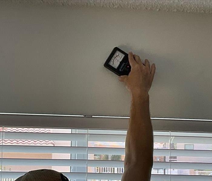 picture of moisture meter on wall reading the moisture. 