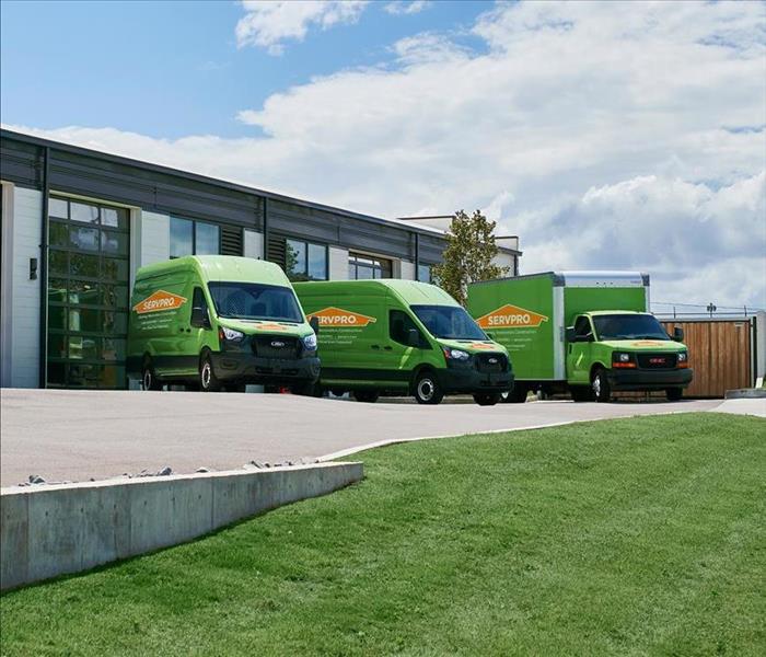 a picture of three SERVPRO trucks outside a facility, line up perfectly. 